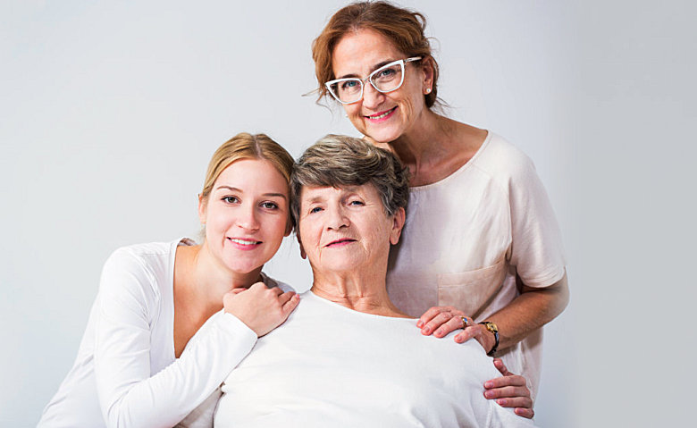 caregivers and old woman smiling